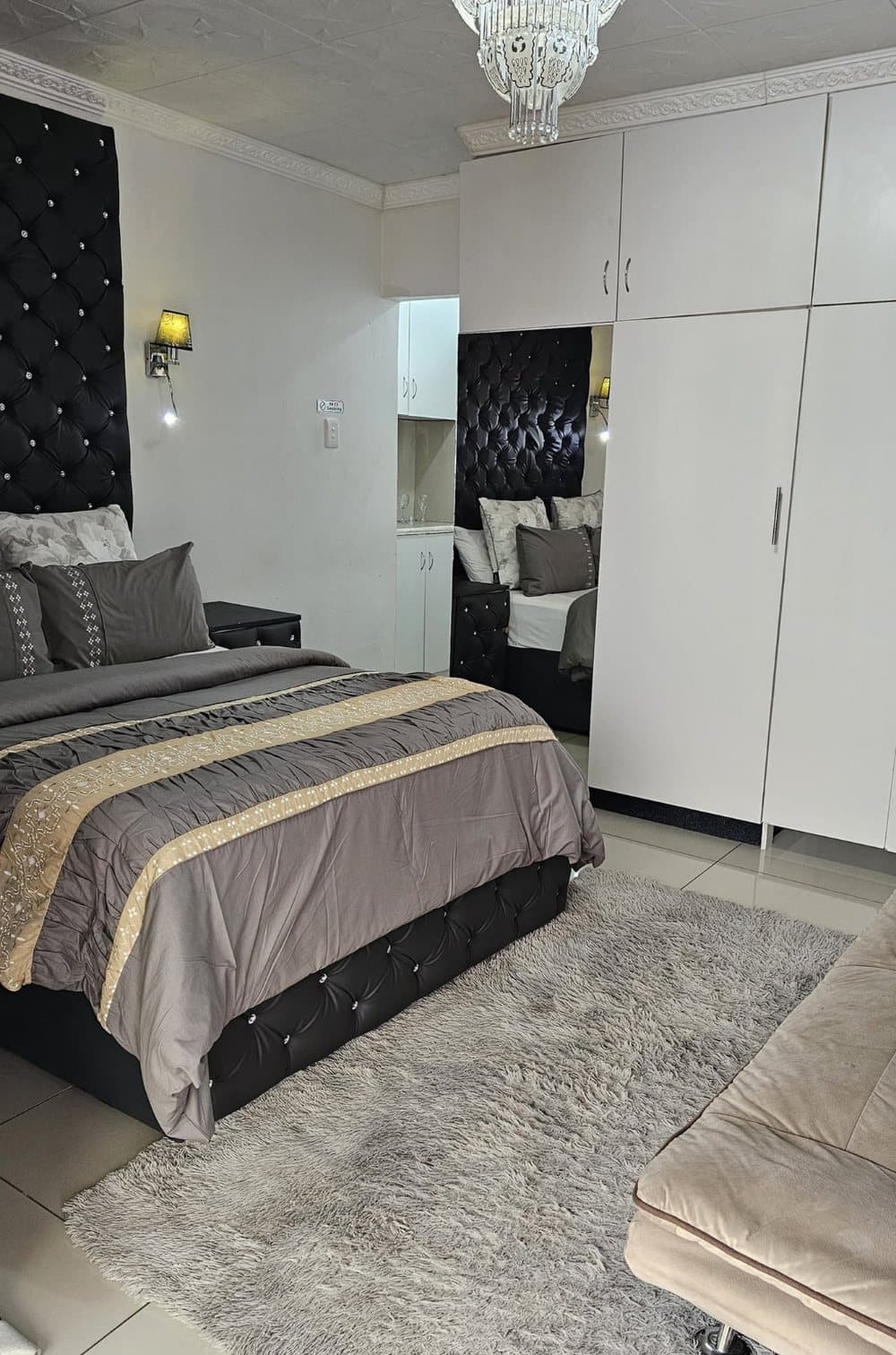 RJ's Guesthouse studio apartment with double bed, tufted headboard and kitchenette